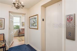A hallway features a closed elevator door, a doorway leading to a room, and artwork — 2407 S ARDSON PLACE UNIT 601, TAMPA, FL