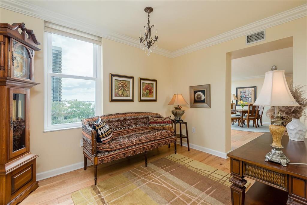 A living room with a patterned settee, a grandfather clock, and a view of buildings — 2407 S ARDSON PLACE UNIT 601, TAMPA, FL