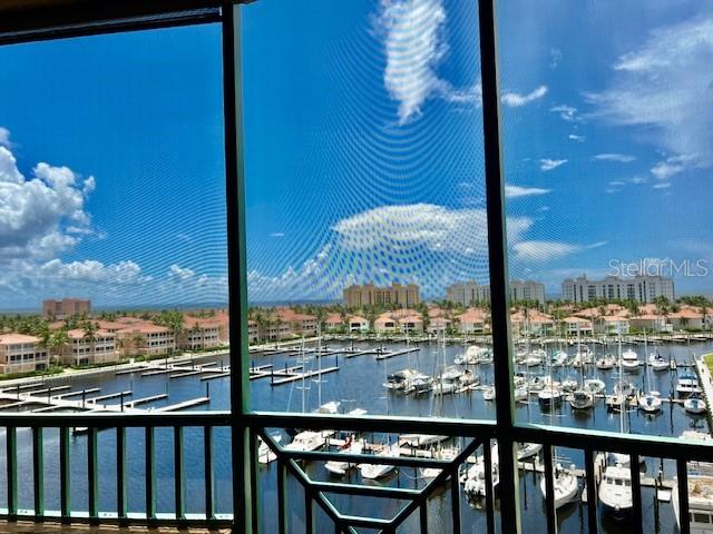 A view from a screened balcony overlooking a marina with many boats and coastal buildings — 2090 MATECUMBE KEY ROAD UNIT 1705, PUNTA GORDA, FL