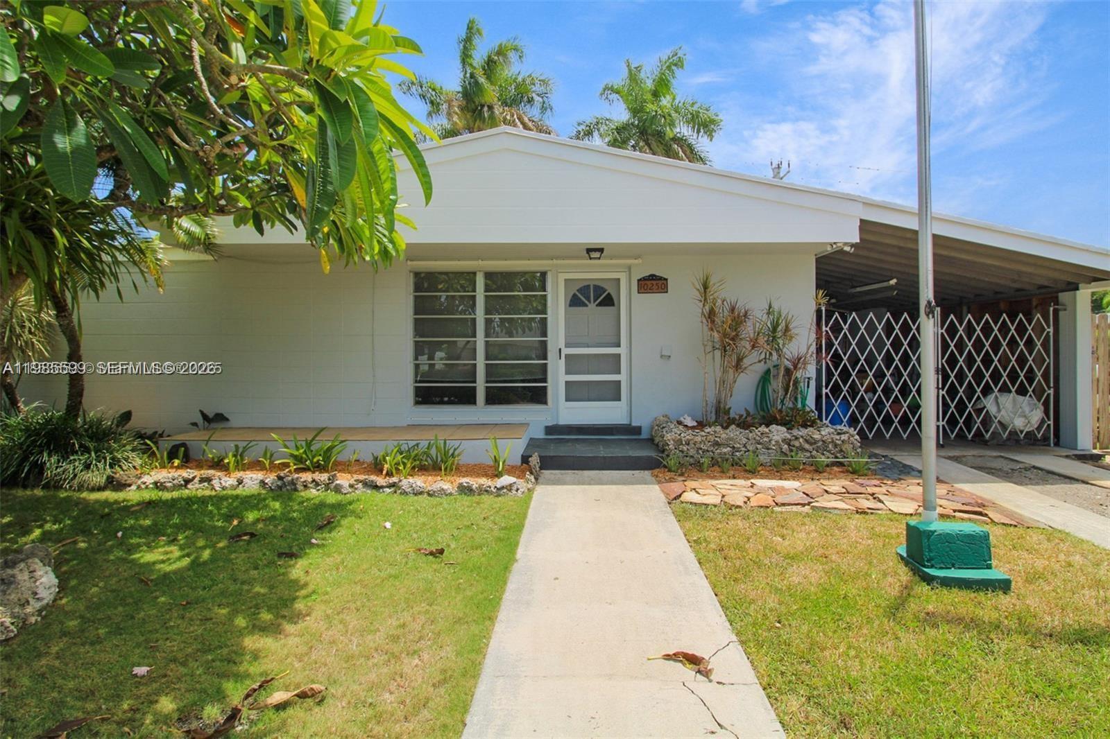 A single-story house with a white exterior, a front walkway, and an attached carport — 10250 Caribbean Blvd, Cutler Bay FL 33189, CUTLER BAY, FL