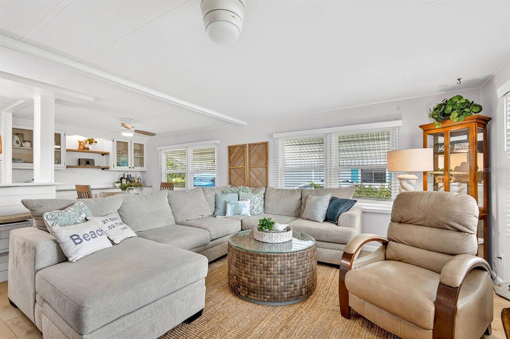 A living room features a large sectional sofa, a round coffee table, and a recliner — 76 CABALLO WAY, BRADENTON, FL