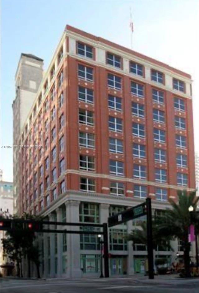 A multi-story brick commercial building with a white stone base stands on a city street — 111 E Flagler St # 410, Miami FL 33131, MIAMI, FL