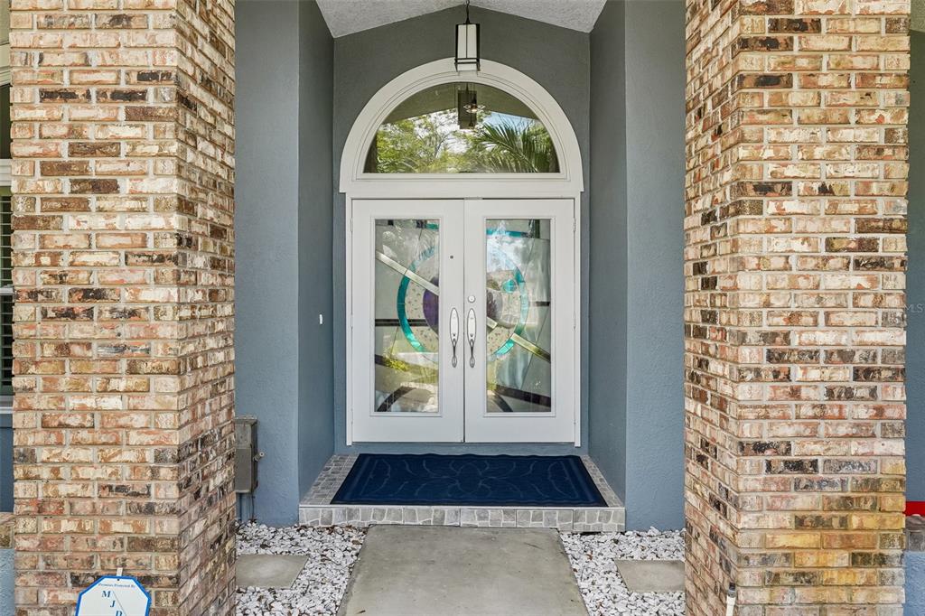 A dining area with yellow chairs, a dark table, and large arched windows — 14426 MARK DRIVE, LARGO, FL