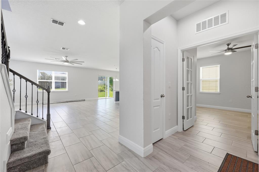 An interior view shows a tiled entryway, a carpeted staircase, and a room with French doors — 4424 SILVER CREEK STREET, KISSIMMEE, FL