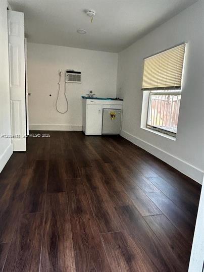 A small room with dark wood-look flooring, a kitchenette cabinet, and a window with blinds — 7714 NW 5th Ave, Miami FL 33150, MIAMI, FL