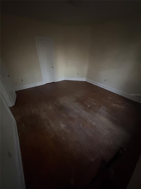 An empty room features light-colored walls, white baseboards, and worn hardwood flooring — 1975 VINEVILLE AVENUE UNIT F3, MACON, GA