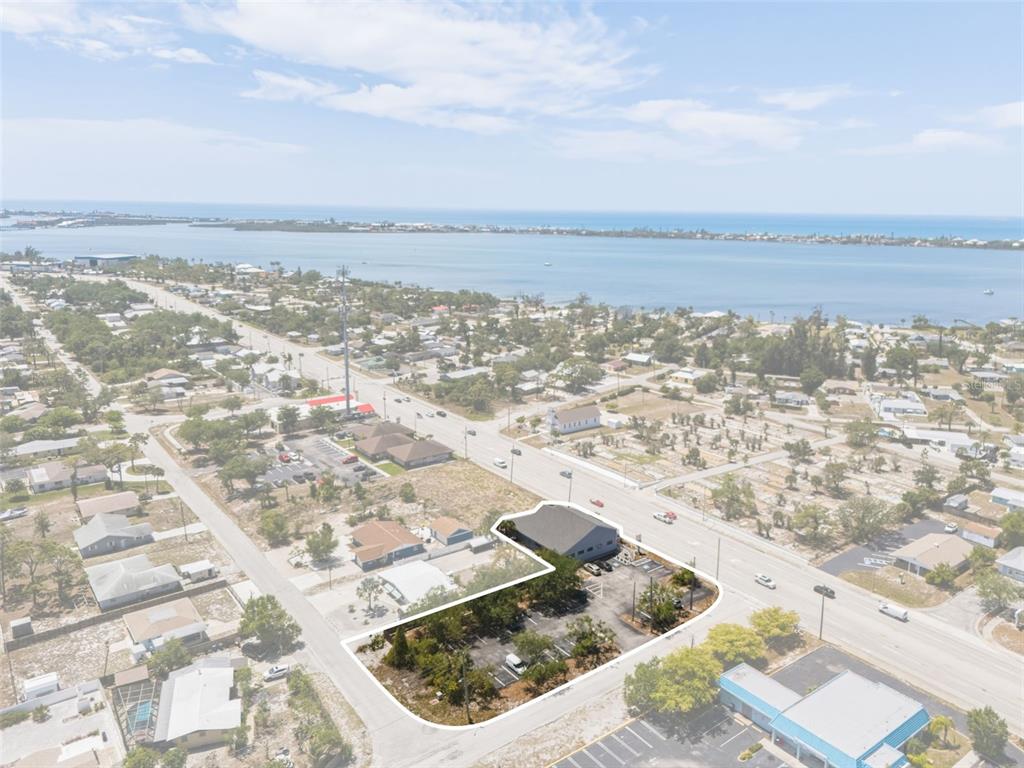 An aerial view shows a commercial building with a parking lot outlined in white — 501 S INDIANA AVENUE, ENGLEWOOD, FL