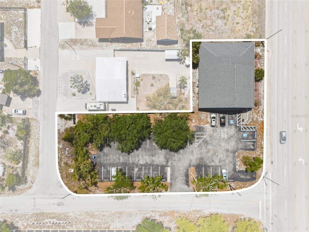 This aerial view shows a commercial building with an adjacent parking lot — 501 S INDIANA AVENUE, ENGLEWOOD, FL