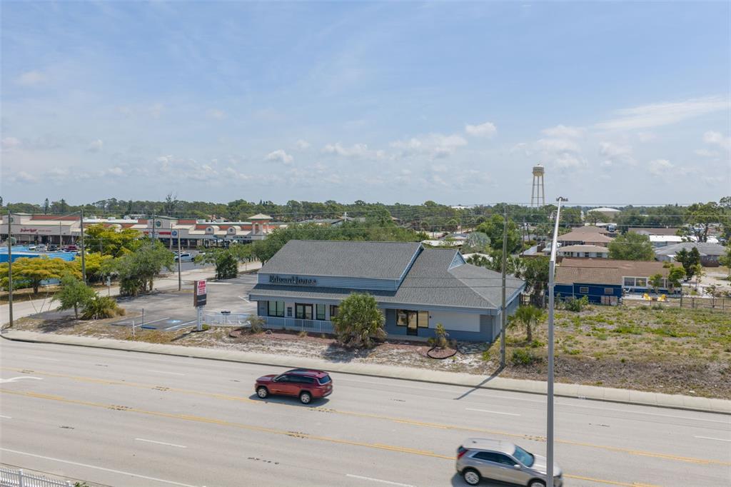 An aerial view shows a commercial building with a gray roof along a multi-lane road — 501 S INDIANA AVENUE, ENGLEWOOD, FL