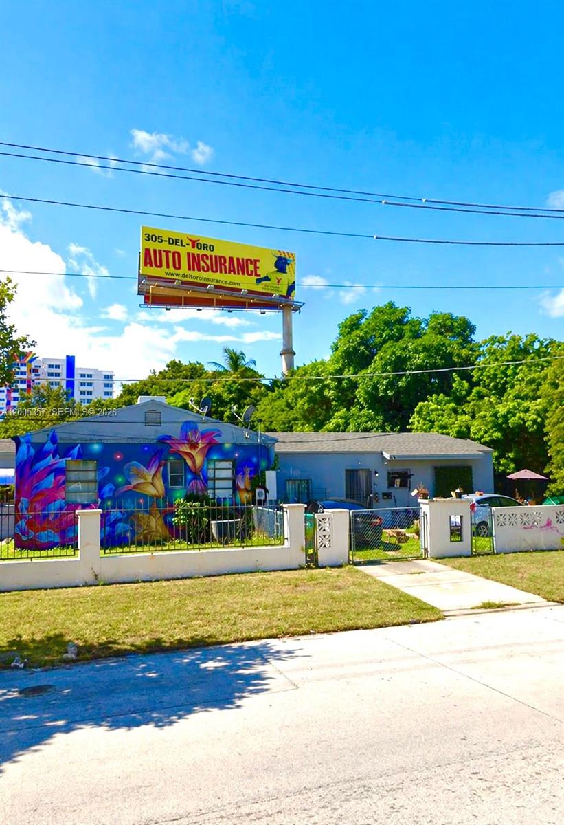 A single-story house features a vibrant floral mural on its exterior wall and a fenced yard — 301 NW 37th St # A, Miami FL 33127, MIAMI, FL