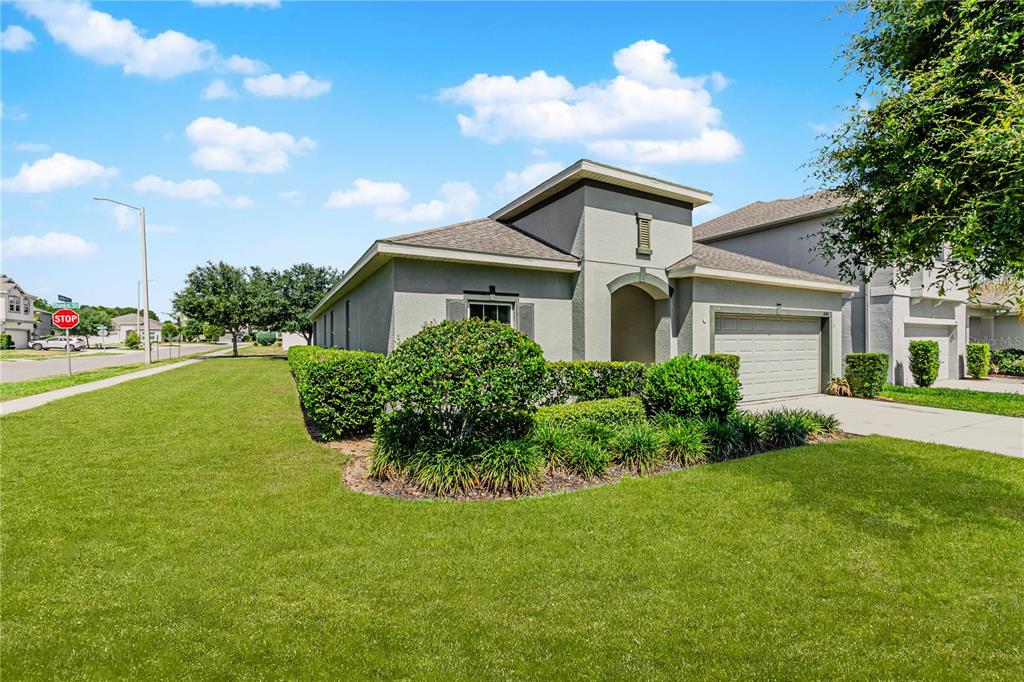 A single-story house with a gray stucco exterior, a two-car garage, and manicured landscaping — 3040 SANDERLING STREET, HAINES CITY, FL