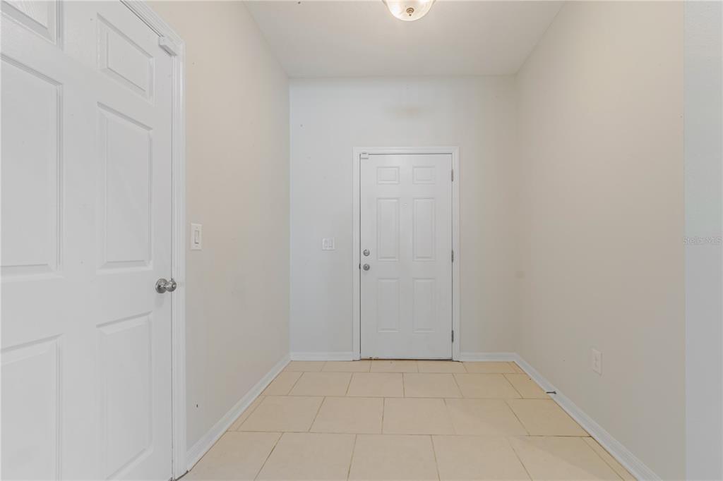 An entryway features light-colored tile flooring, white walls, and two white paneled doors — 3040 SANDERLING STREET, HAINES CITY, FL