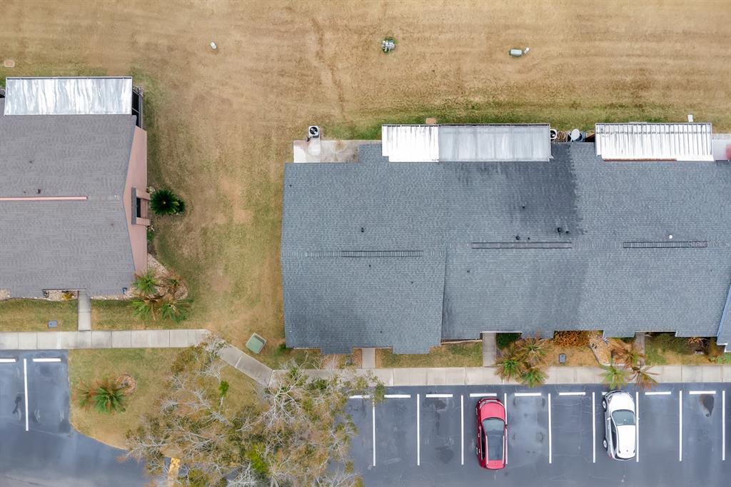 An aerial view shows two residential buildings with gray roofs and a parking lot — 2432 KING OAK COURT, ST CLOUD, FL
