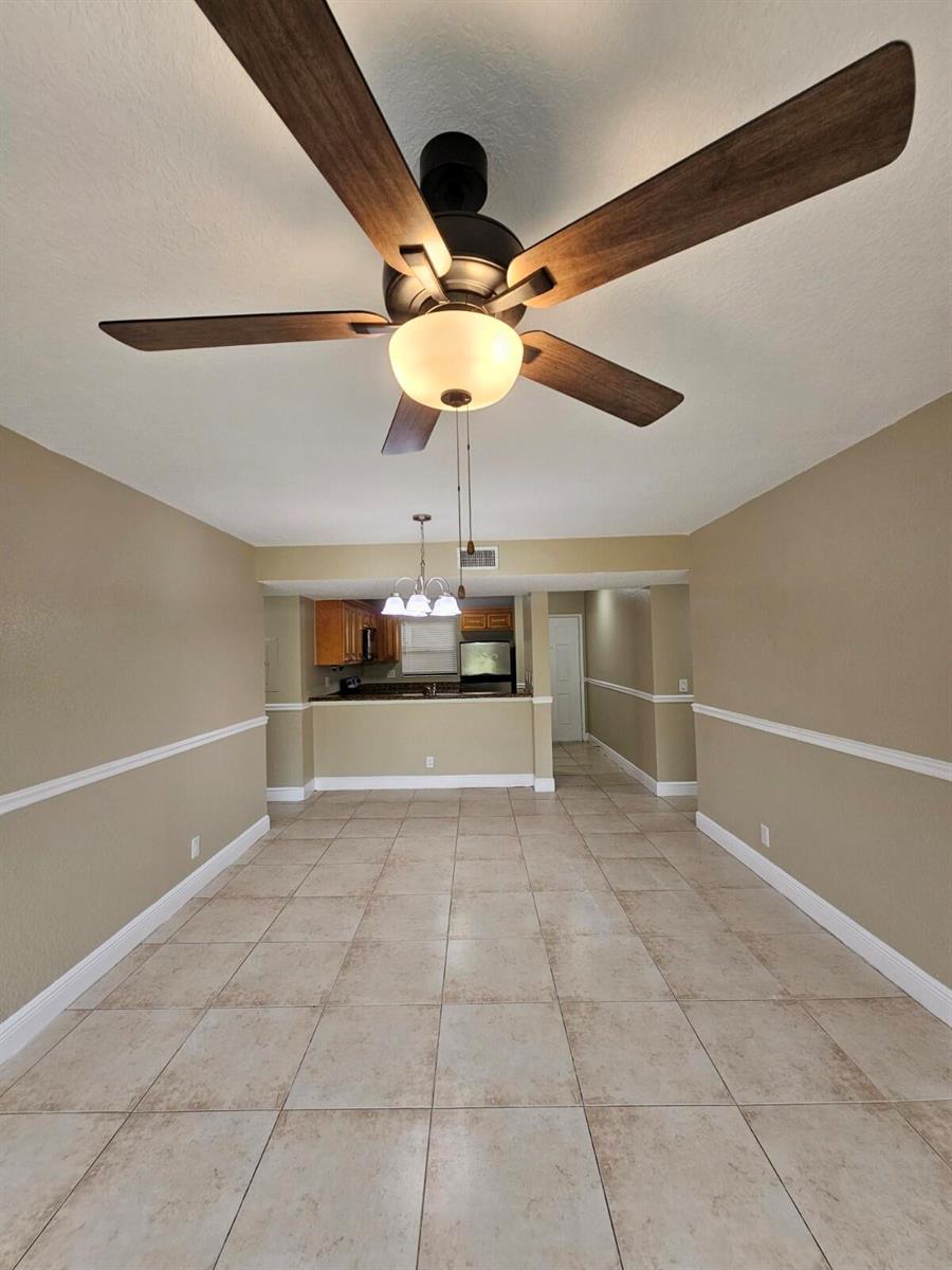 A dining area with tile flooring, a ceiling fan, and an open view of the kitchen — 1541 Windorah Way # C, West Palm Beach FL 33411, WEST PALM BEACH, FL