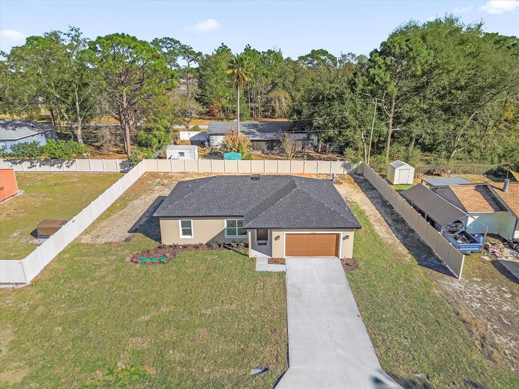 An aerial view shows a single-story house with a dark roof, garage, and fenced yard — 12345 SE 99TH AVENUE, BELLEVIEW, FL