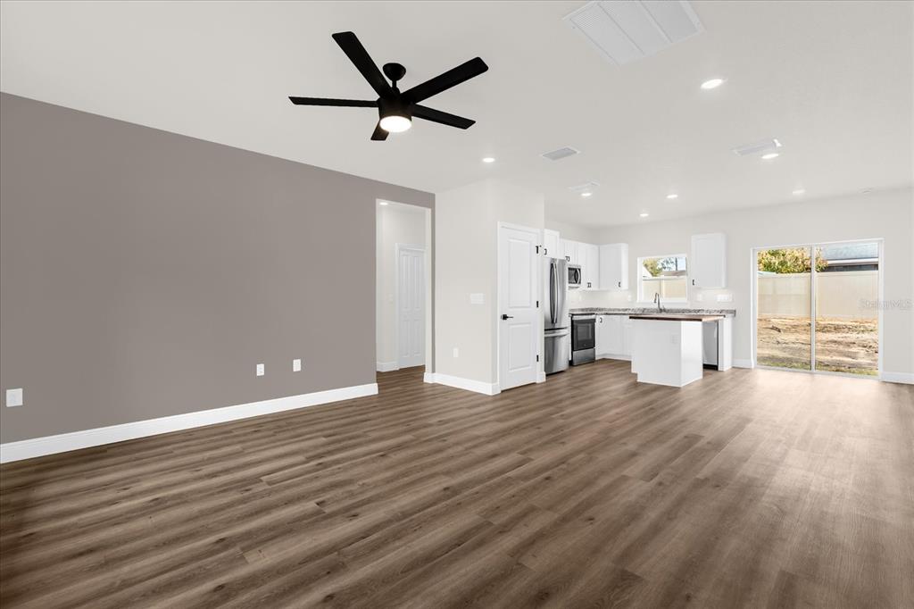 This is a digital rendering of an open-concept living and dining area with wood flooring — 12345 SE 99TH AVENUE, BELLEVIEW, FL