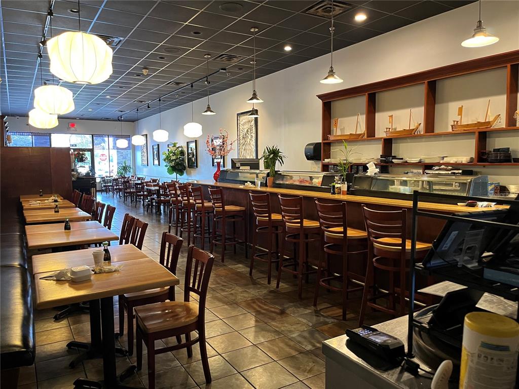 A restaurant interior features a sushi bar, wooden tables, chairs, and pendant lighting — 4742 FLORIDA AVE SOUTH, LAKELAND, FL