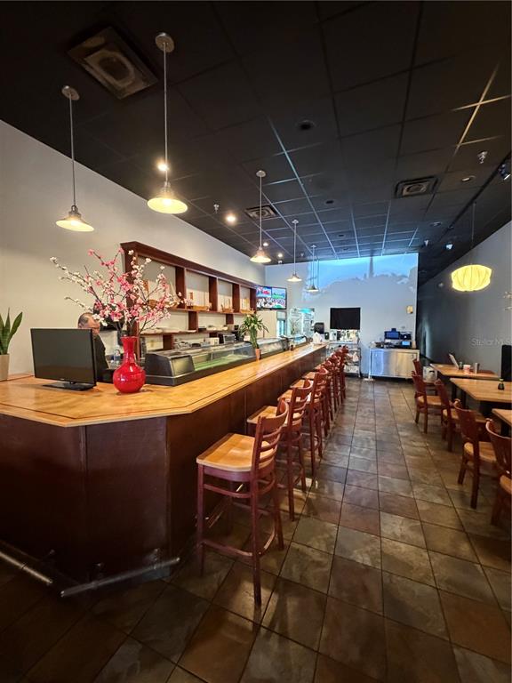 A restaurant interior features a long wooden sushi bar with stools and pendant lighting — 4742 FLORIDA AVE SOUTH, LAKELAND, FL