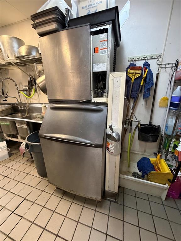 A commercial kitchen features a large ice machine, a utility sink, and cleaning supplies — 4742 FLORIDA AVE SOUTH, LAKELAND, FL