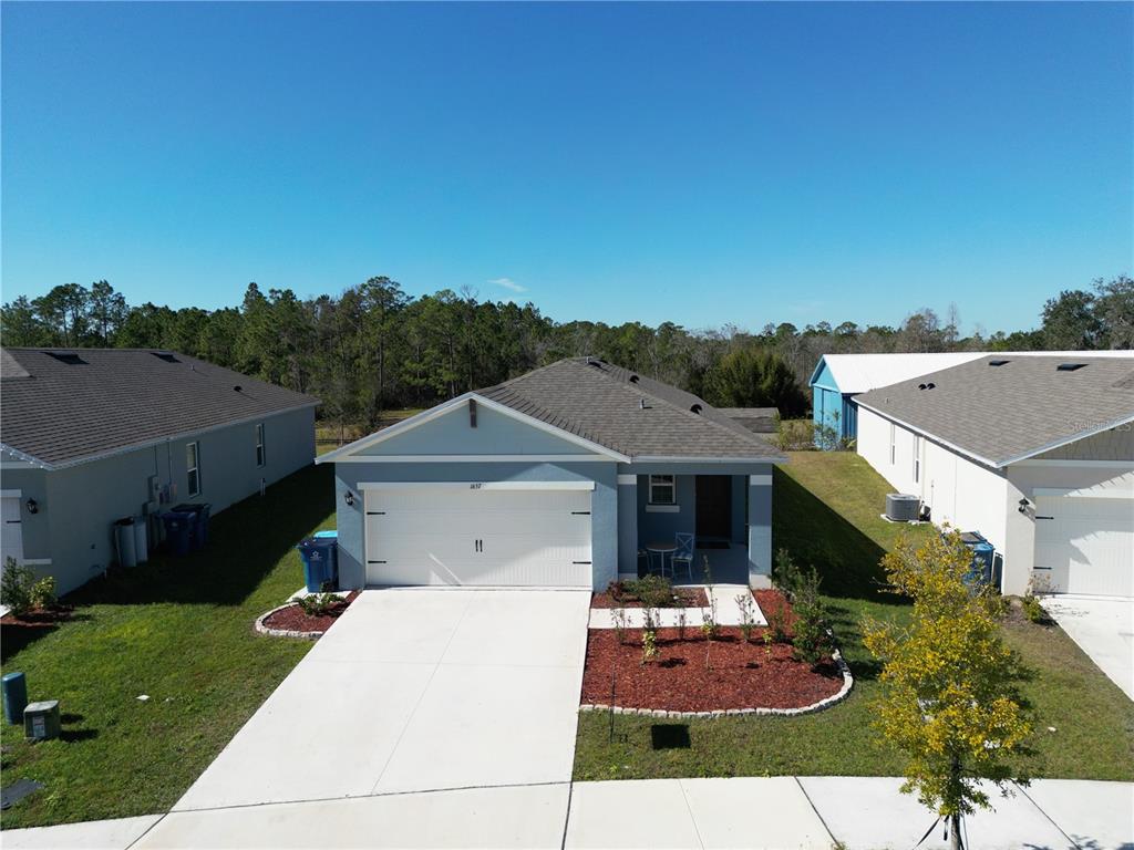 An aerial view of a light blue single-story house with a two-car garage and driveway — 1657 ROSYDALE CIRCLE, DAVENPORT, FL