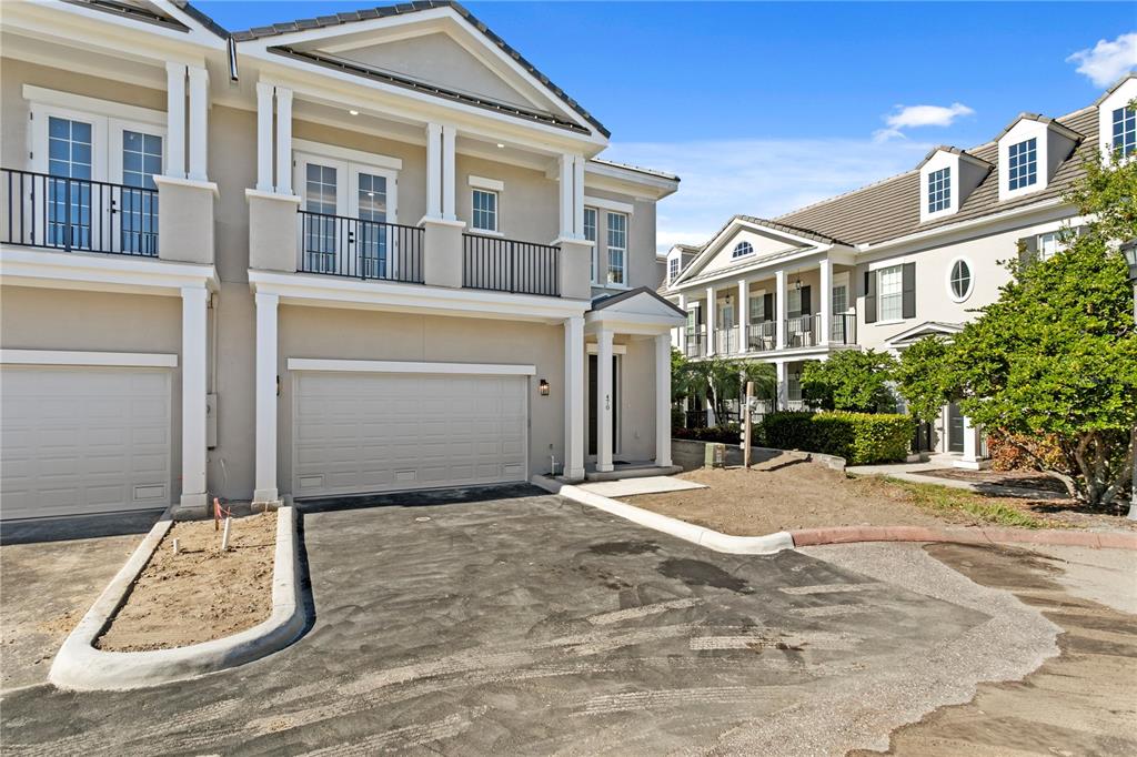 A two-story townhouse with a beige exterior, a two-car garage, and a balcony — 460 GILMAN PLACE N, ST PETERSBURG, FL