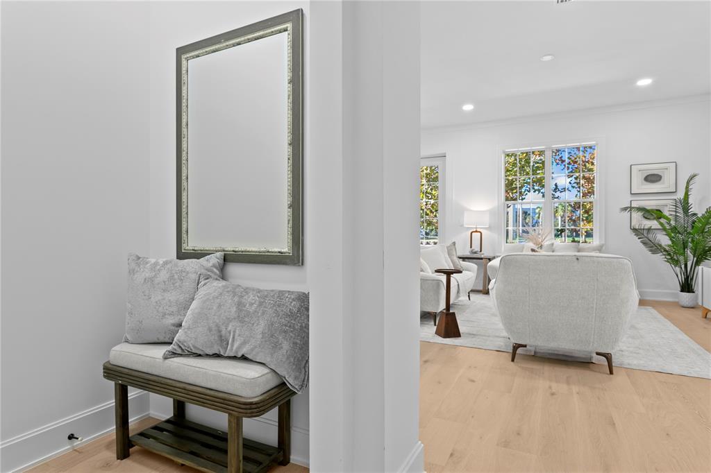 A hallway with a bench and mirror leads into a bright, open-concept living room — 460 GILMAN PLACE N, ST PETERSBURG, FL