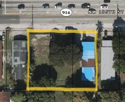 This aerial view shows a rectangular plot of land highlighted in yellow between two buildings — 3160 NW 135th St, Opa-Locka FL 33054, OPA-LOCKA, FL