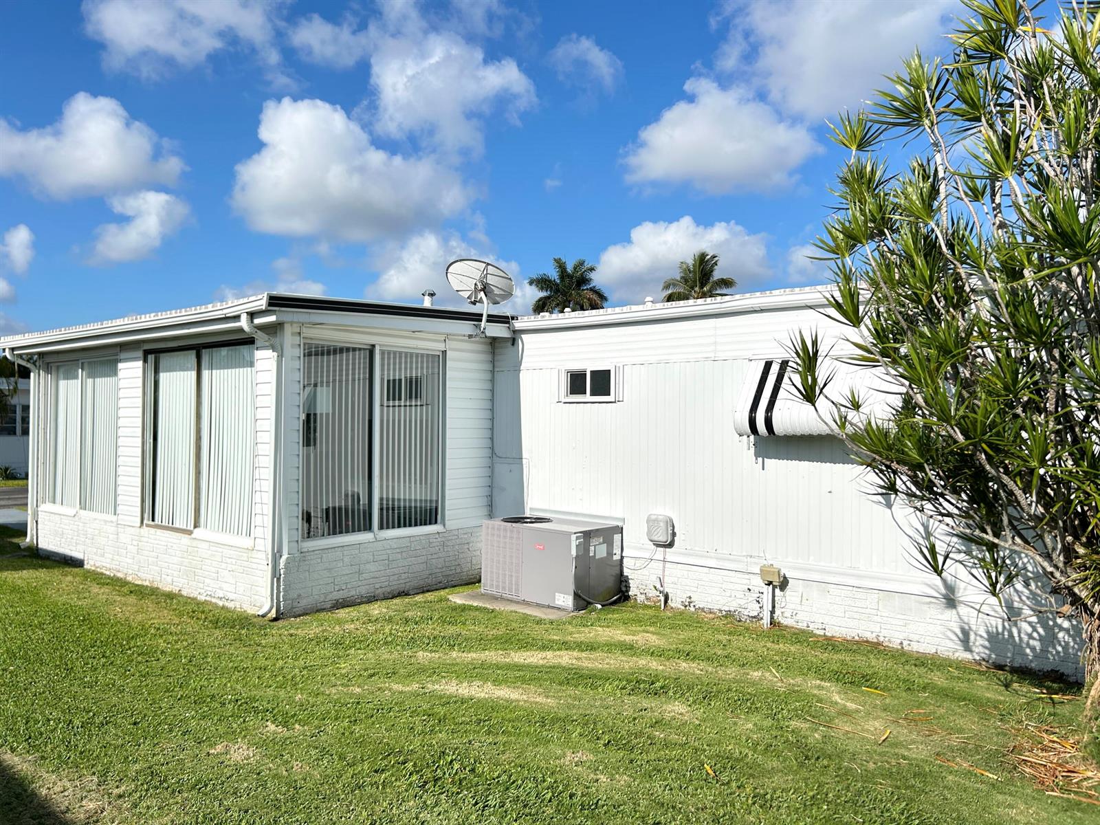 Exterior view of a white mobile home with a satellite dish and central air unit — 3233 State Street, Hollywood FL 33021, HOLLYWOOD, FL
