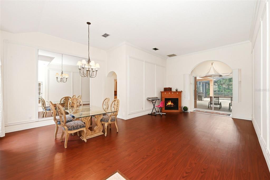 A dining area with a glass table, fireplace, and sliding glass doors to a patio — 483 WEKIVA PRESERVE DRIVE, APOPKA, FL
