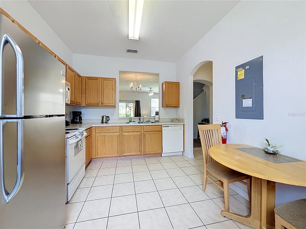 A kitchen with light wood cabinets, stainless steel appliances, and a dining table — 220 TERRA LAGO STREET, DAVENPORT, FL