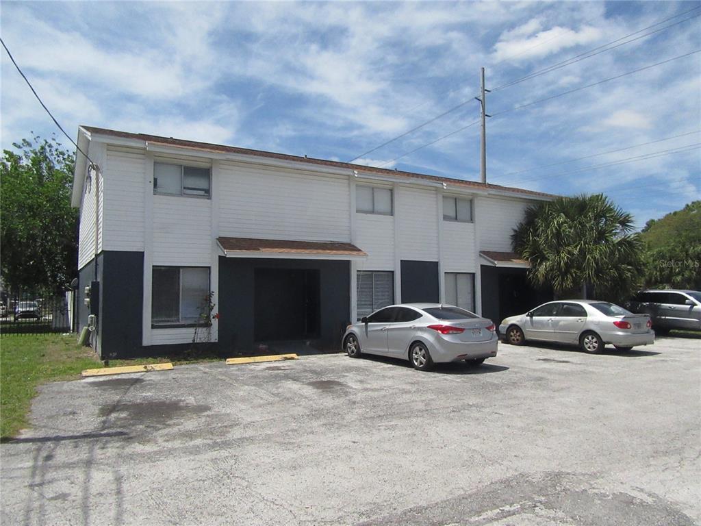 A two-story apartment building with white siding, dark gray lower walls, and a parking lot — 13050 N 20TH STREET, TAMPA, FL