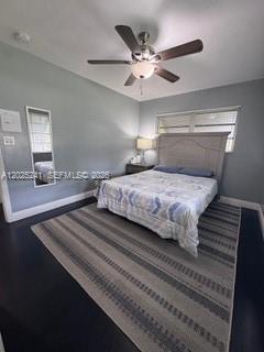 A bedroom features a bed with a patterned quilt, a ceiling fan, and a striped rug — FORT LAUDERDALE, FL