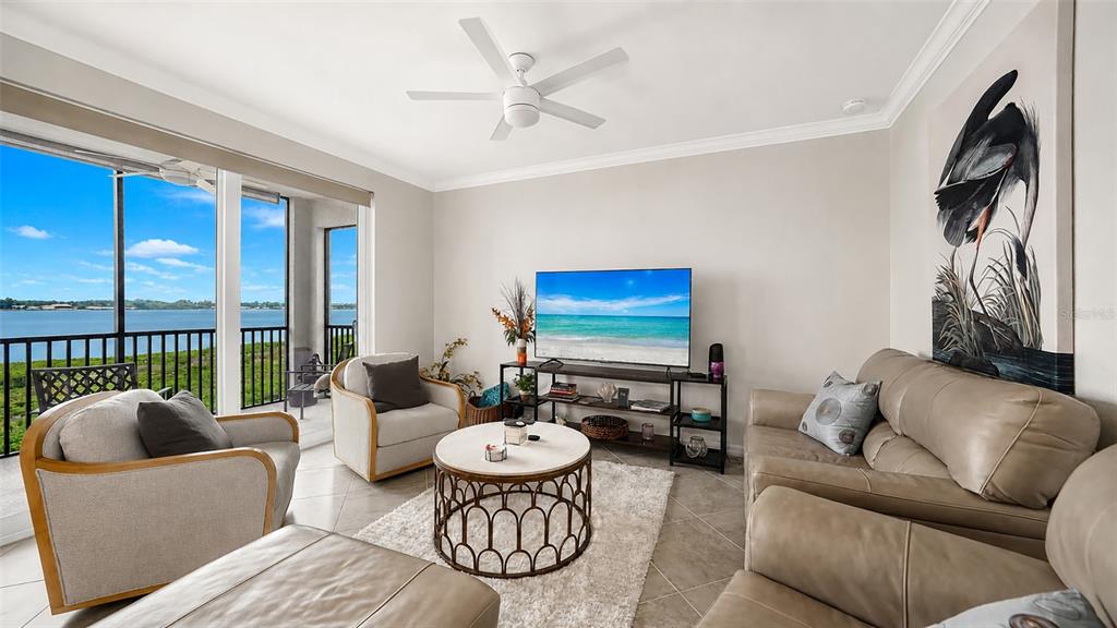 A living room features a beige sofa, two armchairs, a coffee table, and a water view — 1020 TIDEWATER SHORES LOOP UNIT 207, BRADENTON, FL