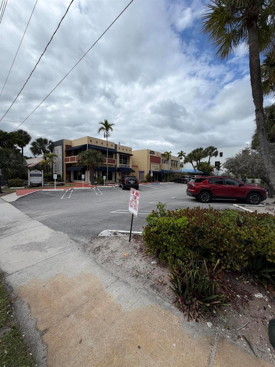 A parking lot sits in front of two commercial buildings under a cloudy sky — 800 Palm Trail, Delray Beach FL 33483, DELRAY BEACH, FL
