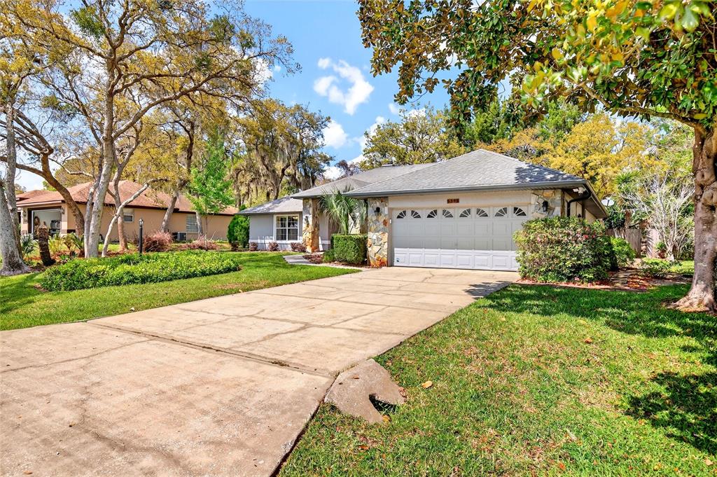 A single-story house with a two-car garage, stone accents, and a concrete driveway — 5393 SW 86TH PLACE, OCALA, FL