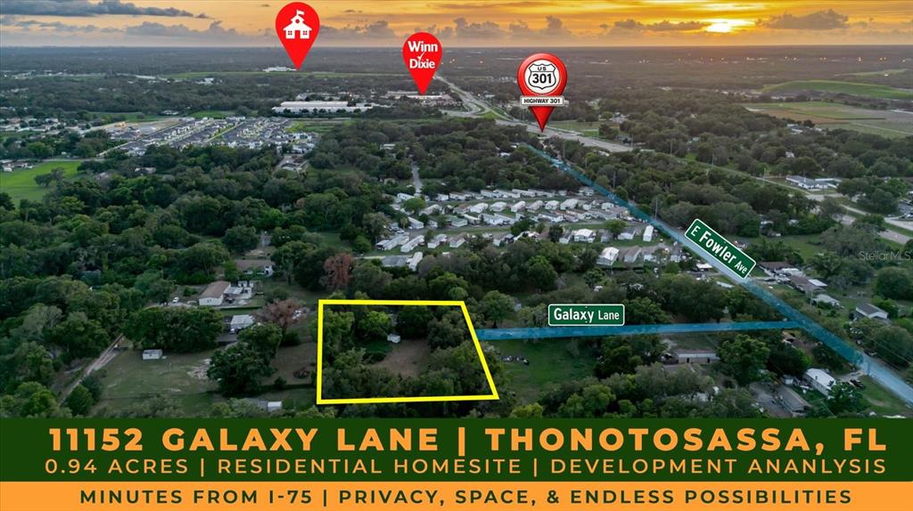 This aerial view shows a wooded residential lot outlined in yellow near a highway intersection — 11152 GALAXY LANE, THONOTOSASSA, FL