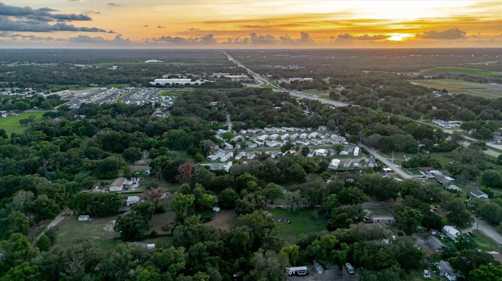 An aerial view shows a rural residential area with scattered houses and trees at sunset — 11152 GALAXY LANE, THONOTOSASSA, FL