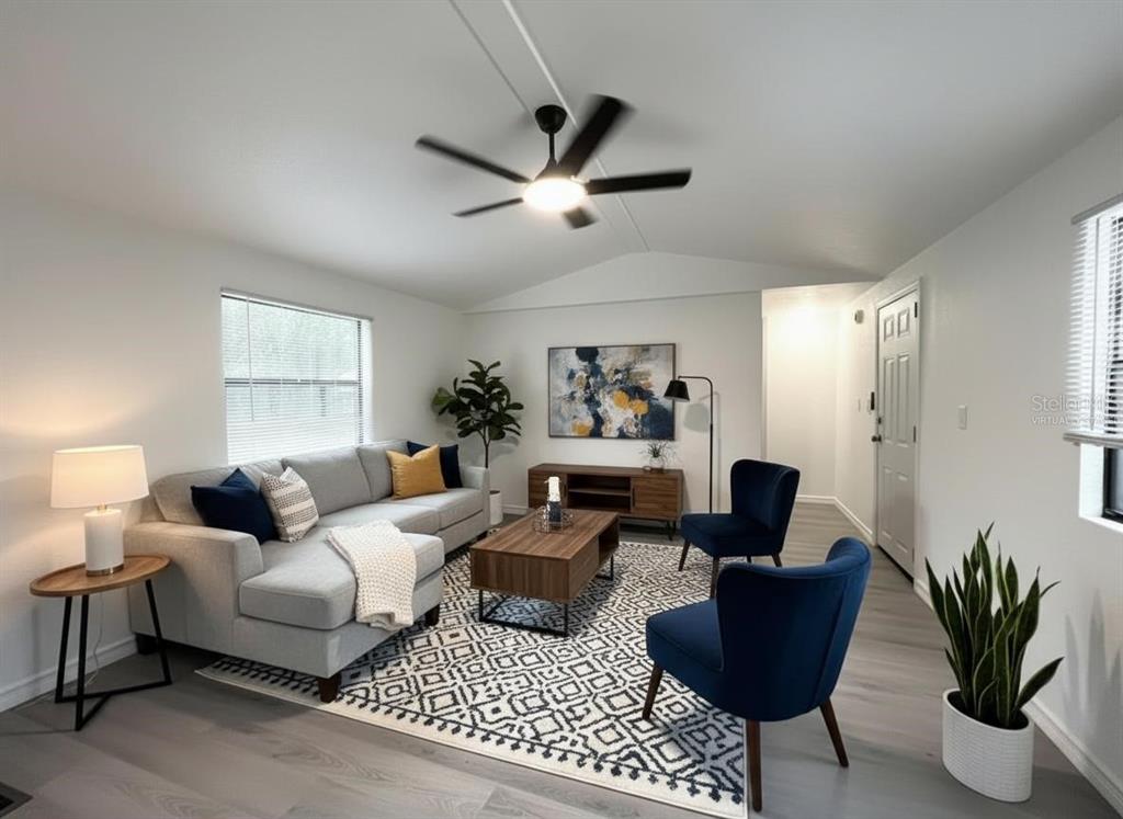 A living room features a gray sectional sofa, two blue armchairs, and a patterned area rug — 9860 GOLDEN LOOP, NEW PORT RICHEY, FL