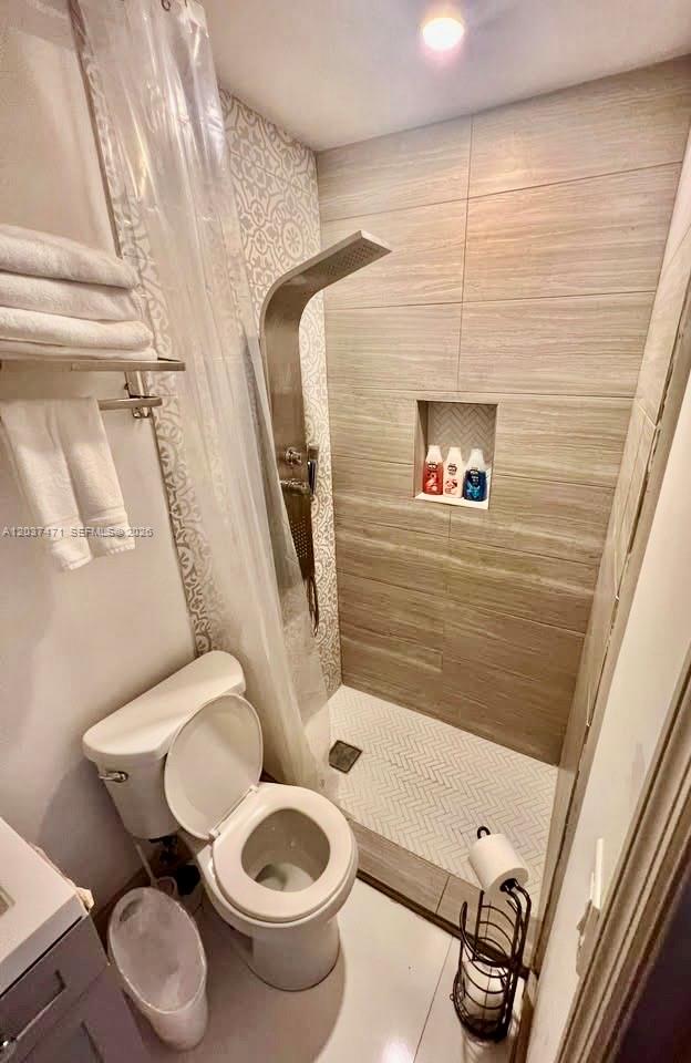 A bathroom features a walk-in shower with a rainfall showerhead, tile walls, and a toilet — 1145 NW 28th St # B, Miami FL 33127, MIAMI, FL