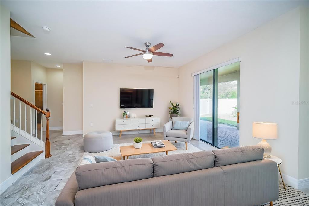 A living room features a grey sofa, a wooden coffee table, and a wall-mounted television — 3280 SOMERSET PARK DRIVE, ORLANDO, FL