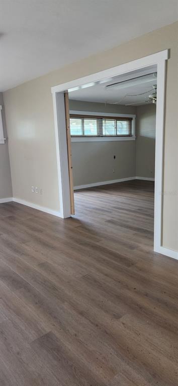A view through a doorway into a room with wood-look flooring and windows — 6961 1ST AVENUE N, ST PETERSBURG, FL