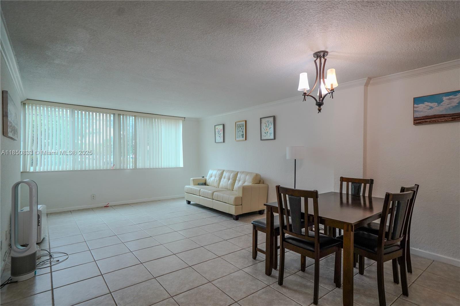 A living and dining area features tile flooring, a beige sofa, and a wooden dining set — 9125 SW 77th Ave # 103, Miami FL 33156, MIAMI, FL
