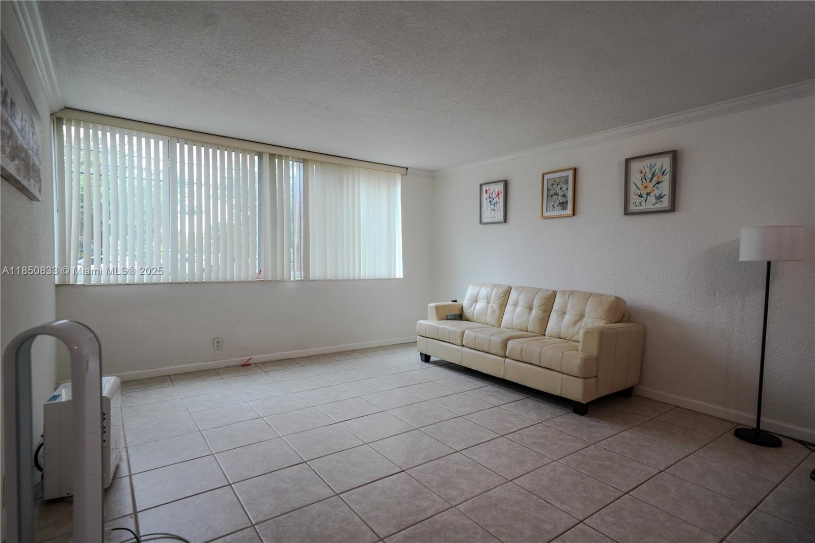 A living room features white walls, tile flooring, a cream sofa, and vertical window blinds — 9125 SW 77th Ave # 103, Miami FL 33156, MIAMI, FL