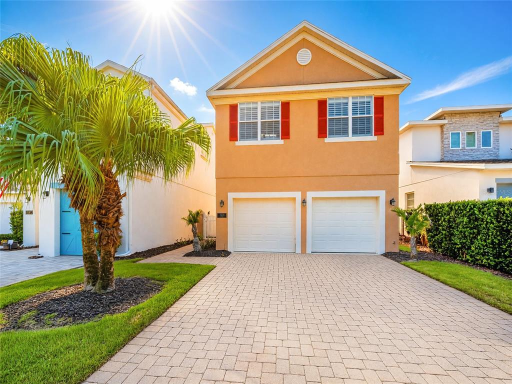 A two-story house with a tan stucco exterior, red shutters, and a two-car garage — 7526 EXCITEMENT DRIVE, REUNION, FL