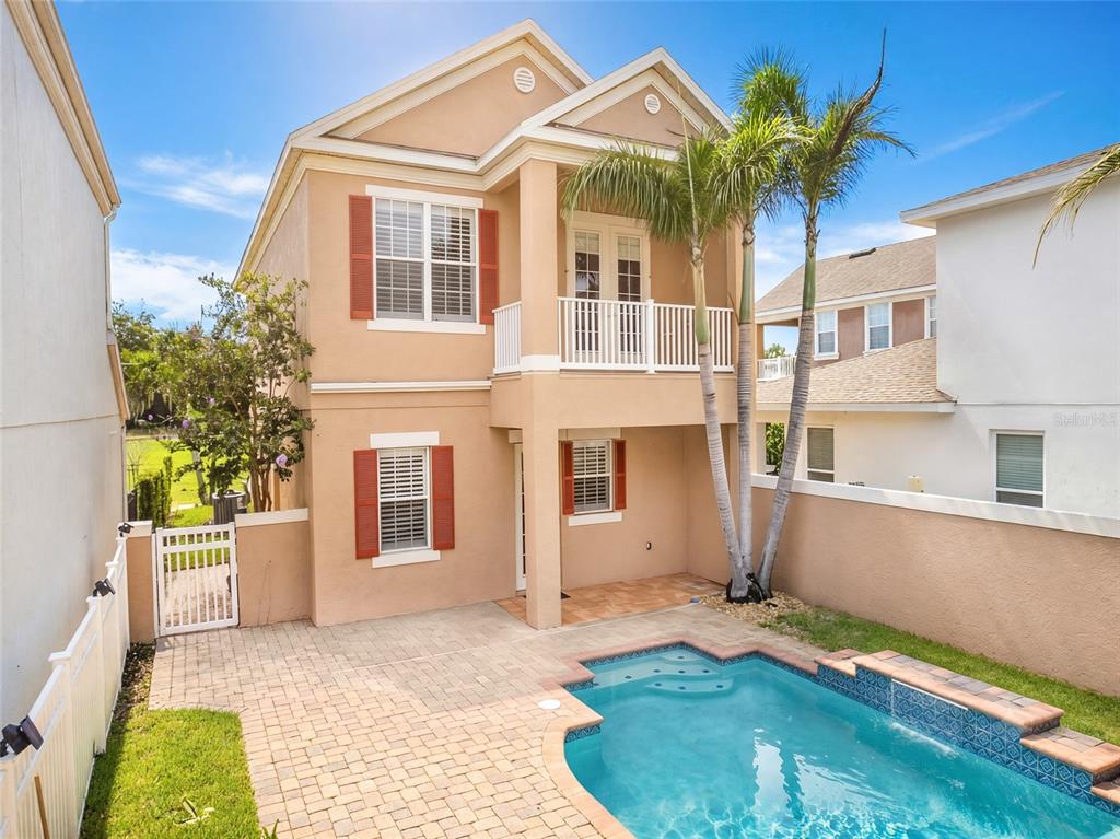 A two-story tan house features a swimming pool, a patio, and a second-floor balcony — 7526 EXCITEMENT DRIVE, REUNION, FL