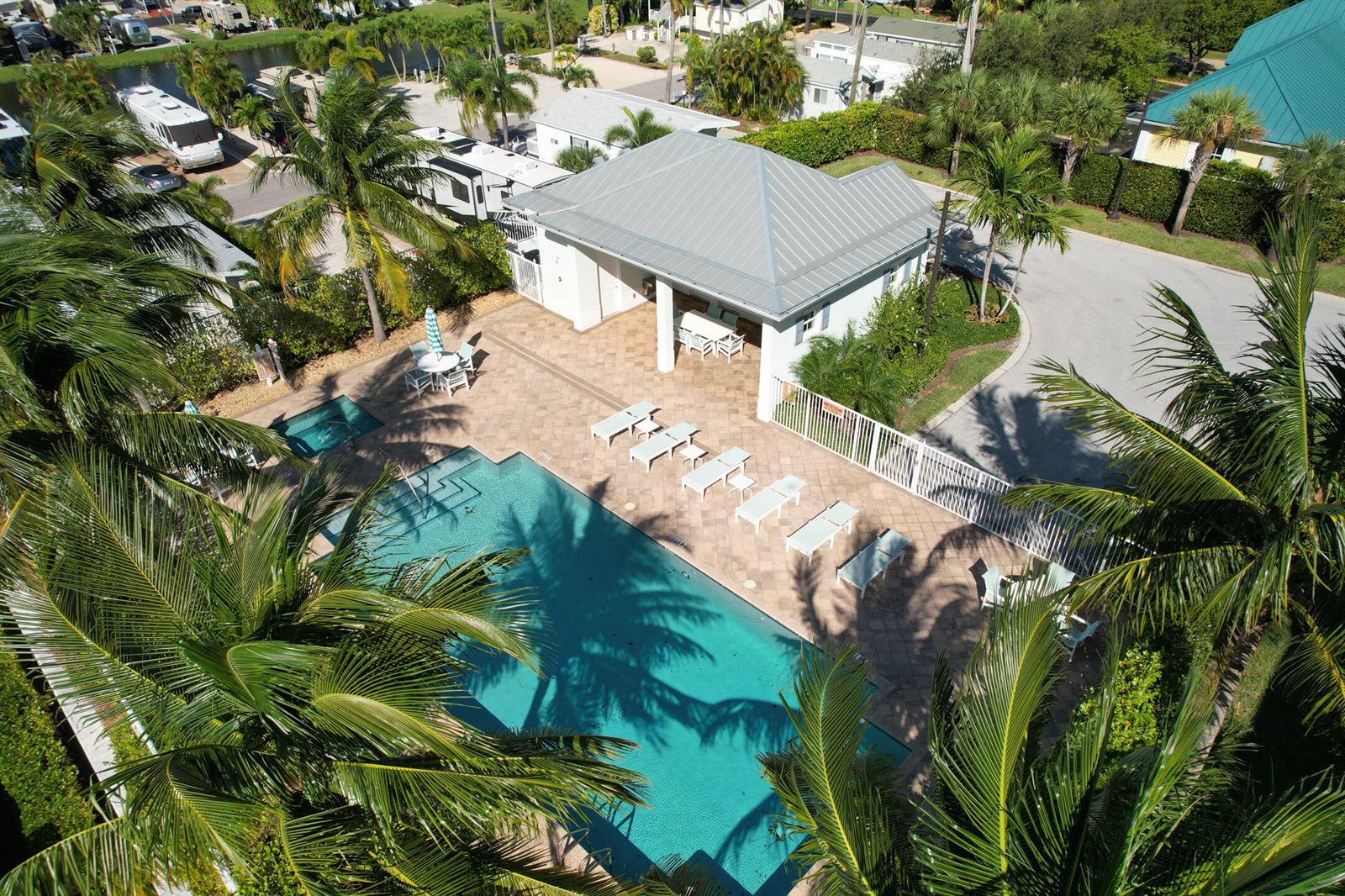An aerial view of a swimming pool, hot tub, and patio area with a clubhouse — 144 Ocean Breeze Drive, Juno Beach FL 33408, JUNO BEACH, FL