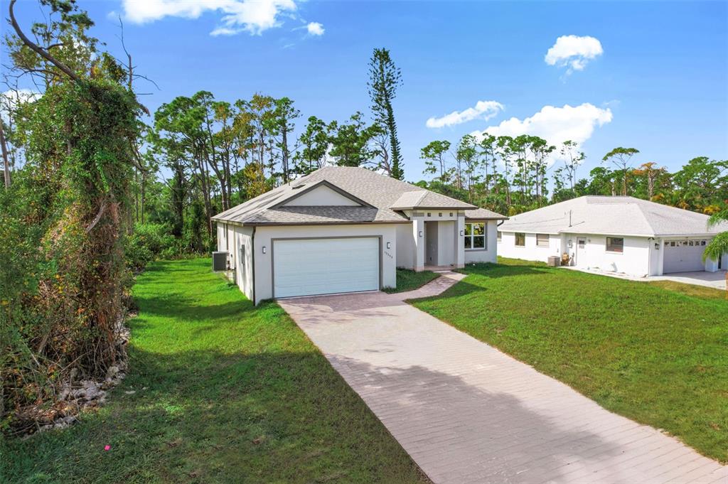 A single-story house with a white exterior, a two-car garage, and a paved driveway — 13353 GORMAN AVENUE, PORT CHARLOTTE, FL