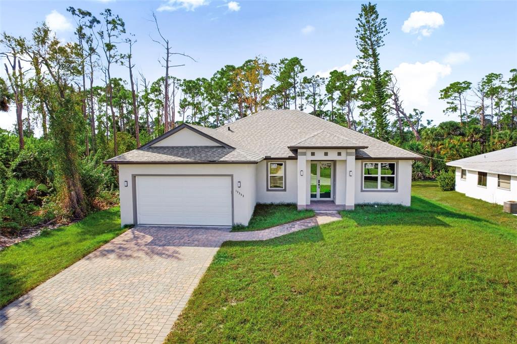 A single-story house with a paved driveway, a two-car garage, and a front entryway — 13353 GORMAN AVENUE, PORT CHARLOTTE, FL