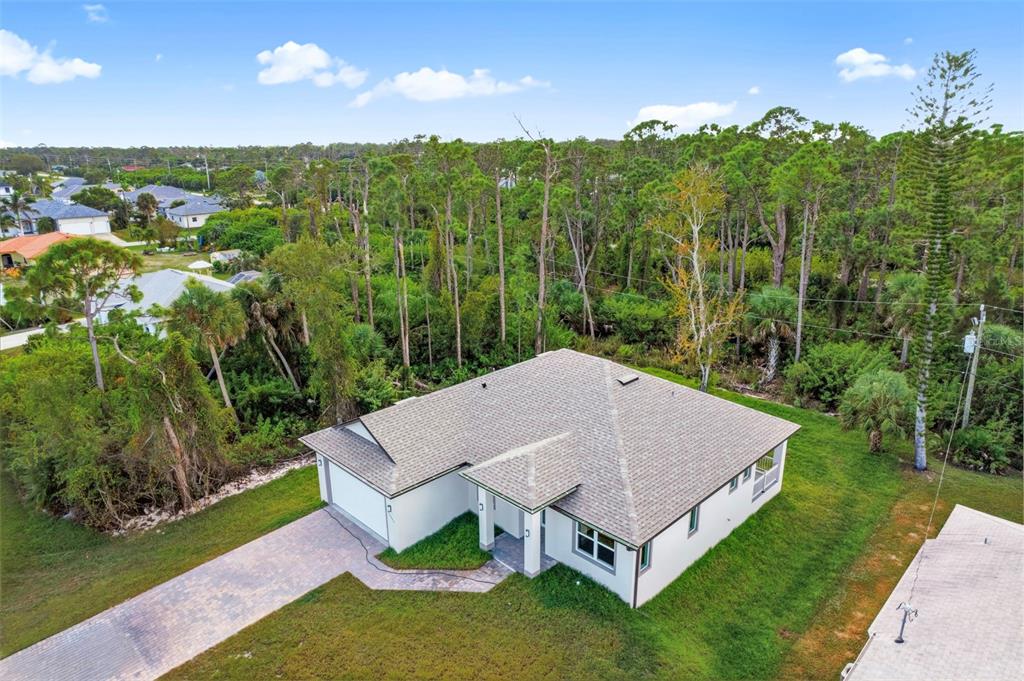 An aerial view shows a single-story house with a gray roof and a paved driveway — 13353 GORMAN AVENUE, PORT CHARLOTTE, FL