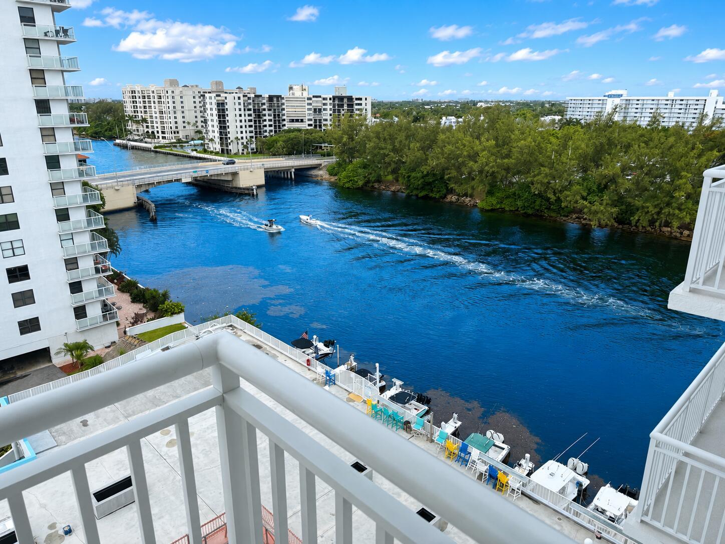 An elevated view from a balcony overlooking a canal with boats and a bridge — 1505 N Riverside Drive # 1002, Pompano Beach FL 33062, POMPANO BEACH, FL